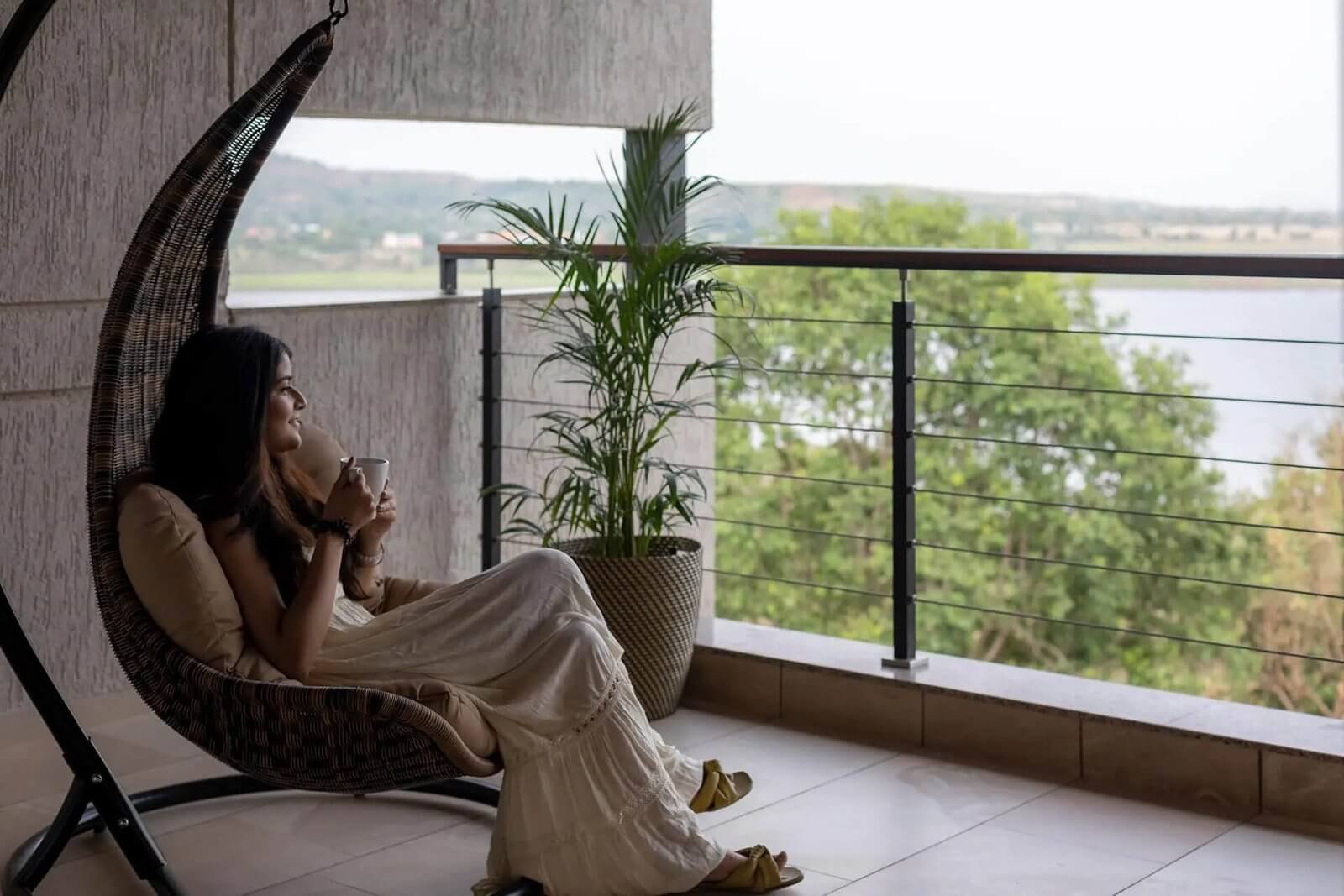 BALCONY · MORNING – Coffee/chai on the rail, lake in soft morning light.